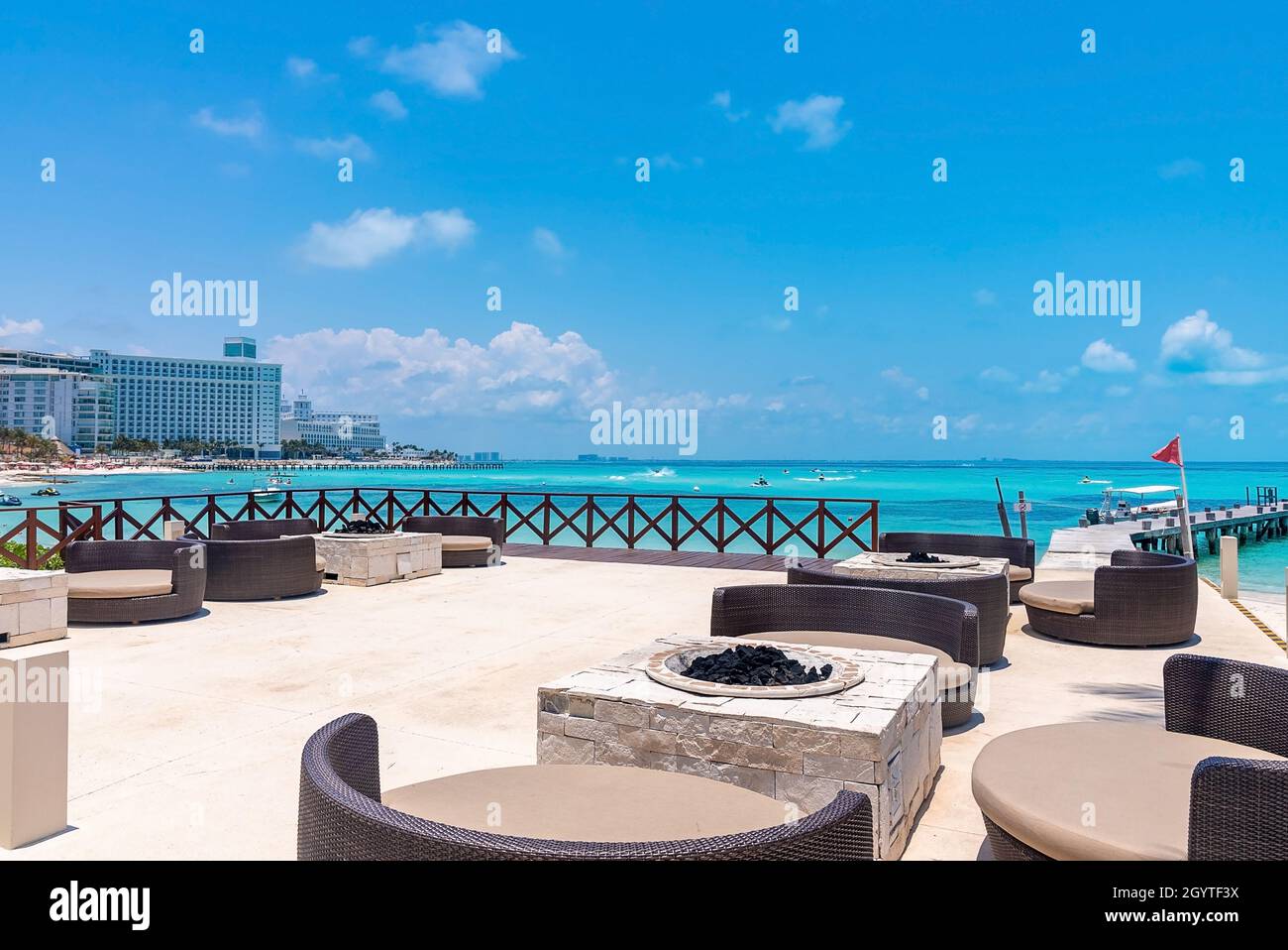 Sedie e tavoli vuoti di ristorante aperto sul molo dal mare Foto Stock