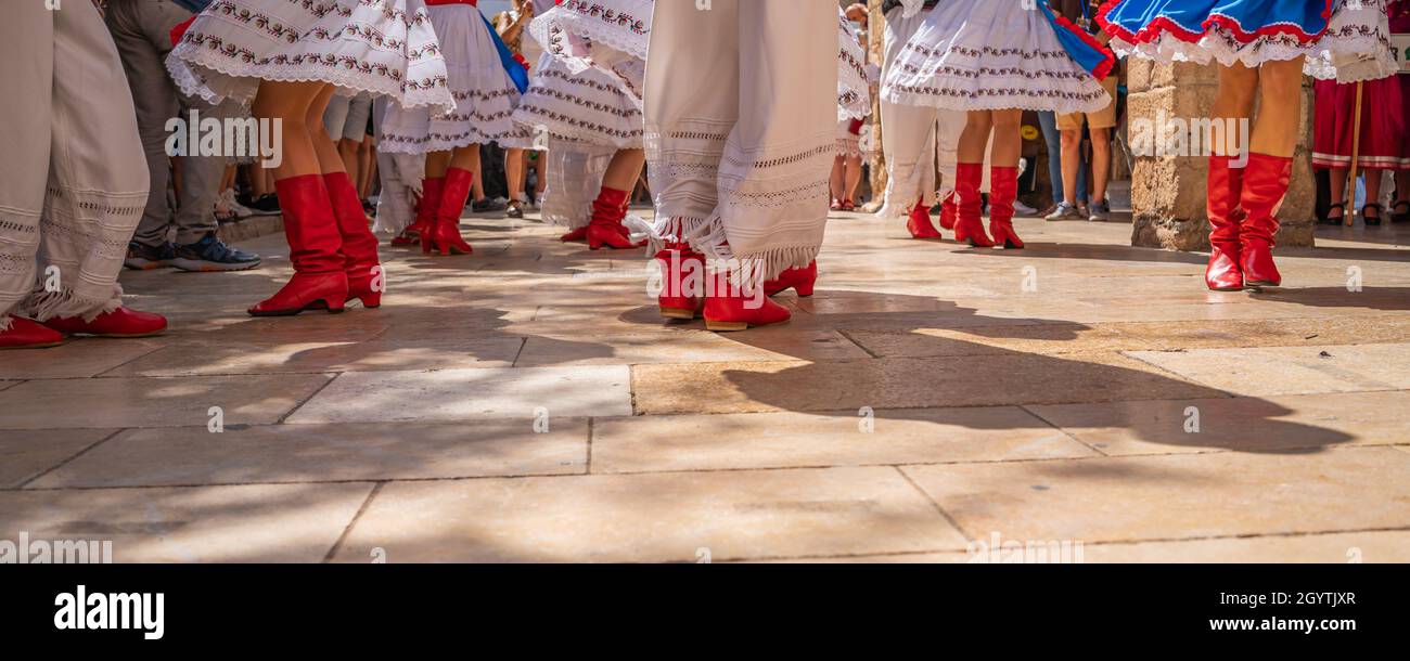 Ballerini in costumi popolari ucraini colorati al festival folk di Montblanc in Spagna, vista con le scarpe rosse Foto Stock