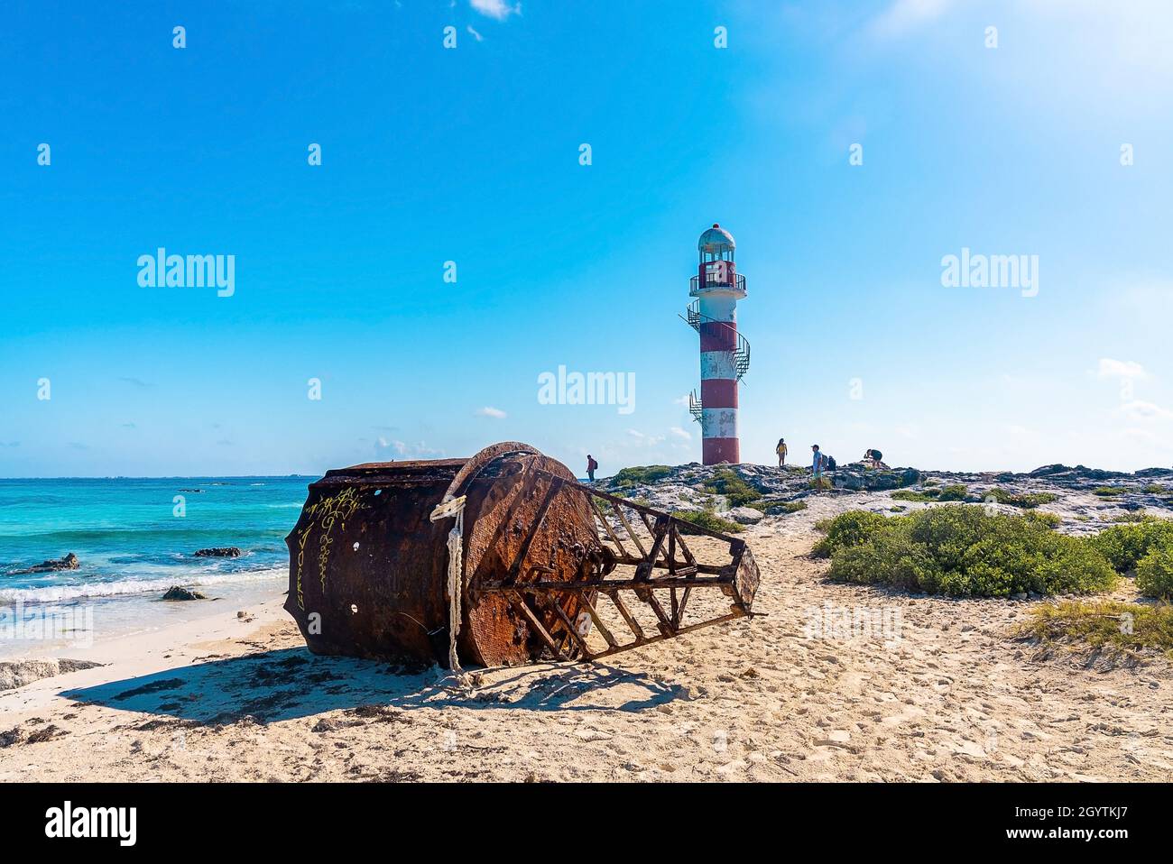 Boa arrugginita con faro in riva al mare contro il cielo Foto Stock