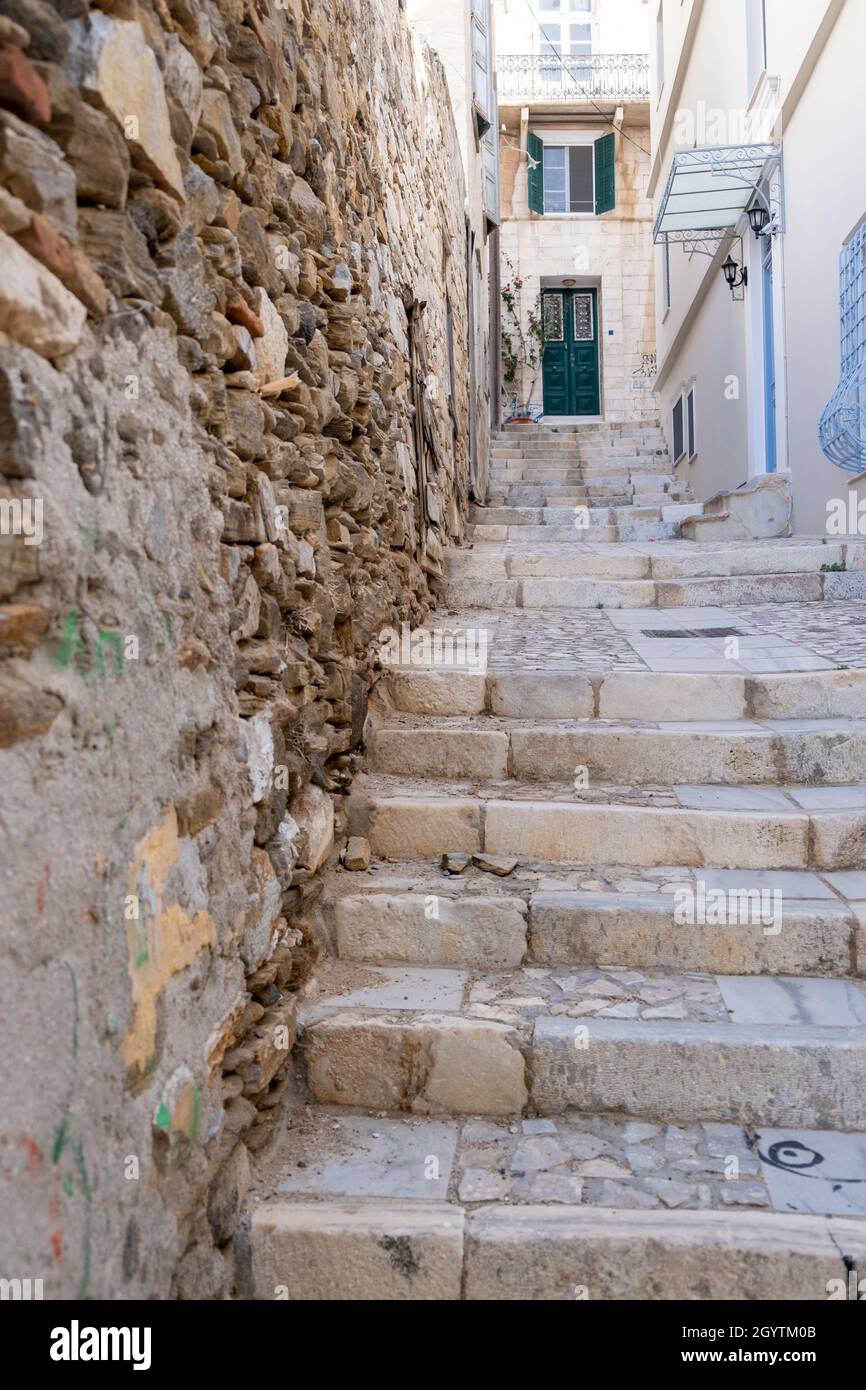 Lastricata vuota e stretta scala esterna si restringe fino alla via superiore accanto a stagionata presso l'isola di Syros, destinazione delle Cicladi Grecia. La scala conduce ai tradizionali Foto Stock