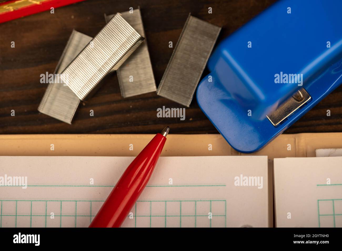 Pinzatrice per ufficio, pinzatrice e carta bianca sul tavolo, primo piano, messa a fuoco selettiva Foto Stock