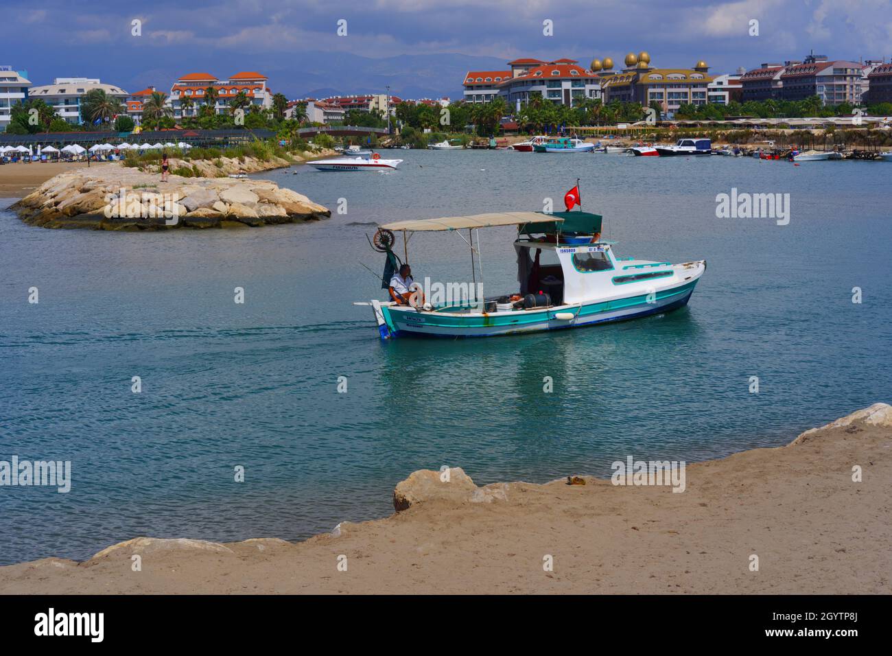 Piccola barca da pesca che ritorna al porto in un giorno nuvoloso al mare Foto Stock