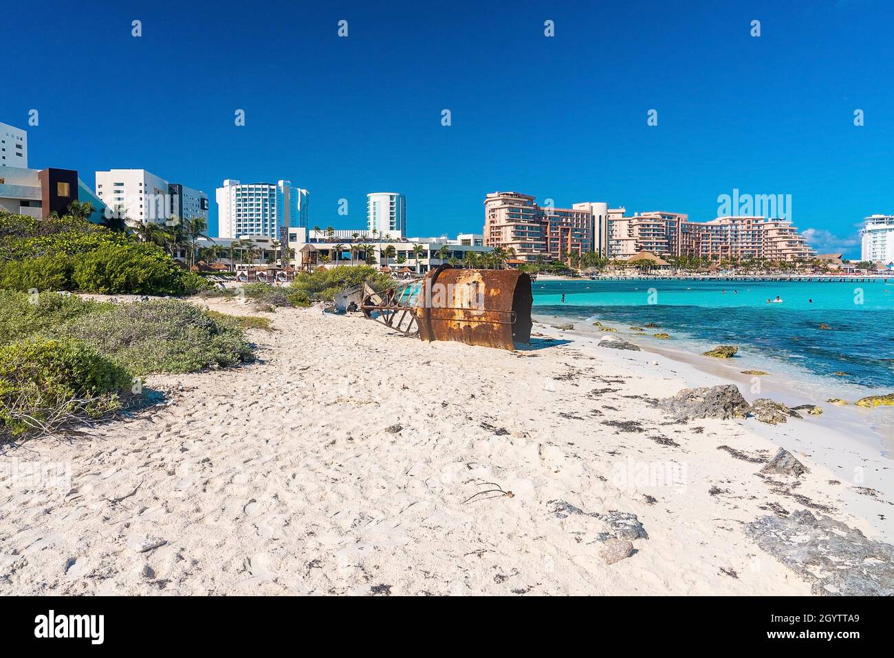 Edifici alberghieri di lusso con relitto di boa nautico sulla spiaggia Foto Stock