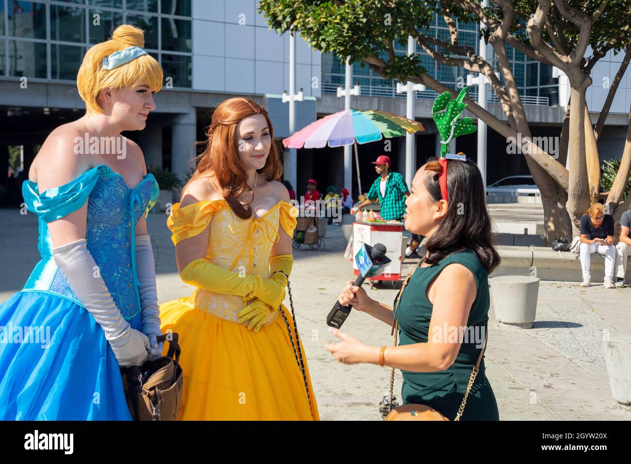 Intervistatore locale VNA TV intervistando le donne partecipanti cosplayers in abiti Disney eroines a Comic con a Los Angeles, CA, Stati Uniti Foto Stock