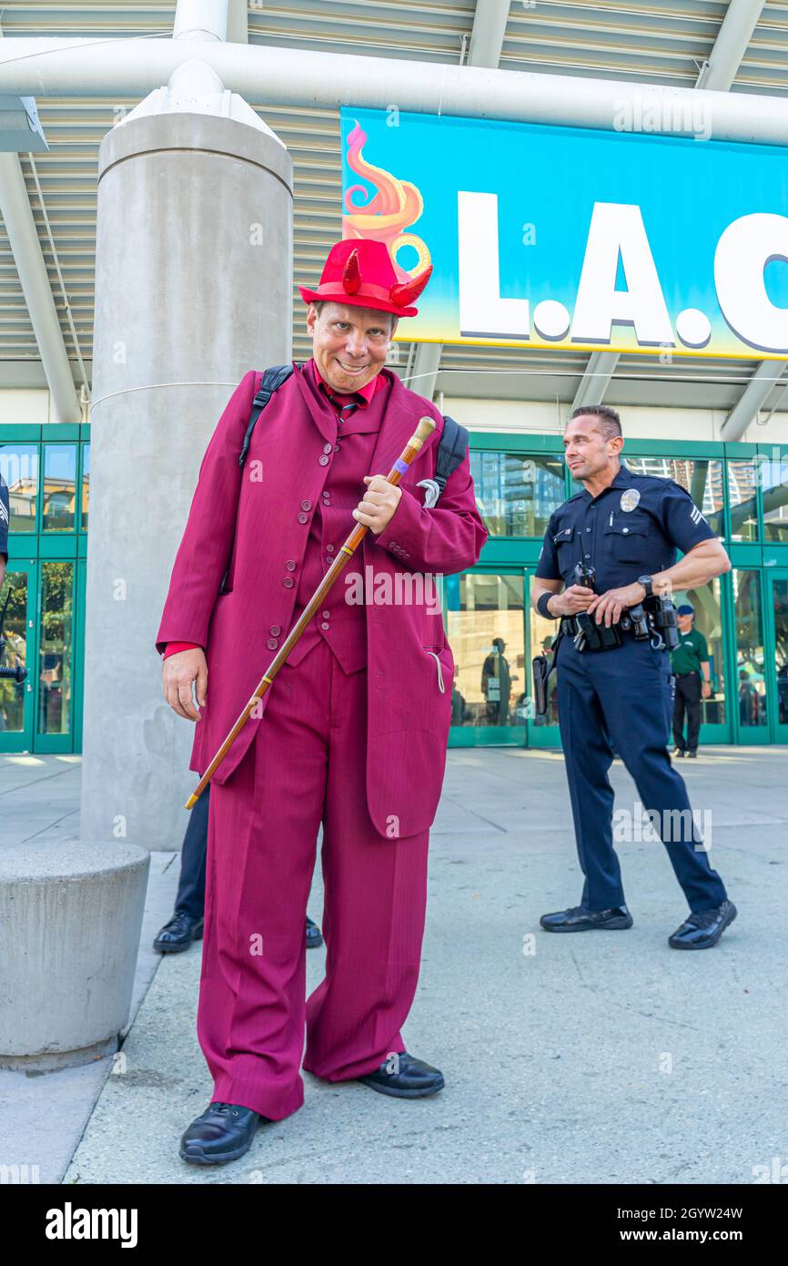 Partecipante coscoplayer raffigurante il Diavolo vestito in rosso con una canna al Comic con a Los Angeles, CA, Stati Uniti Foto Stock