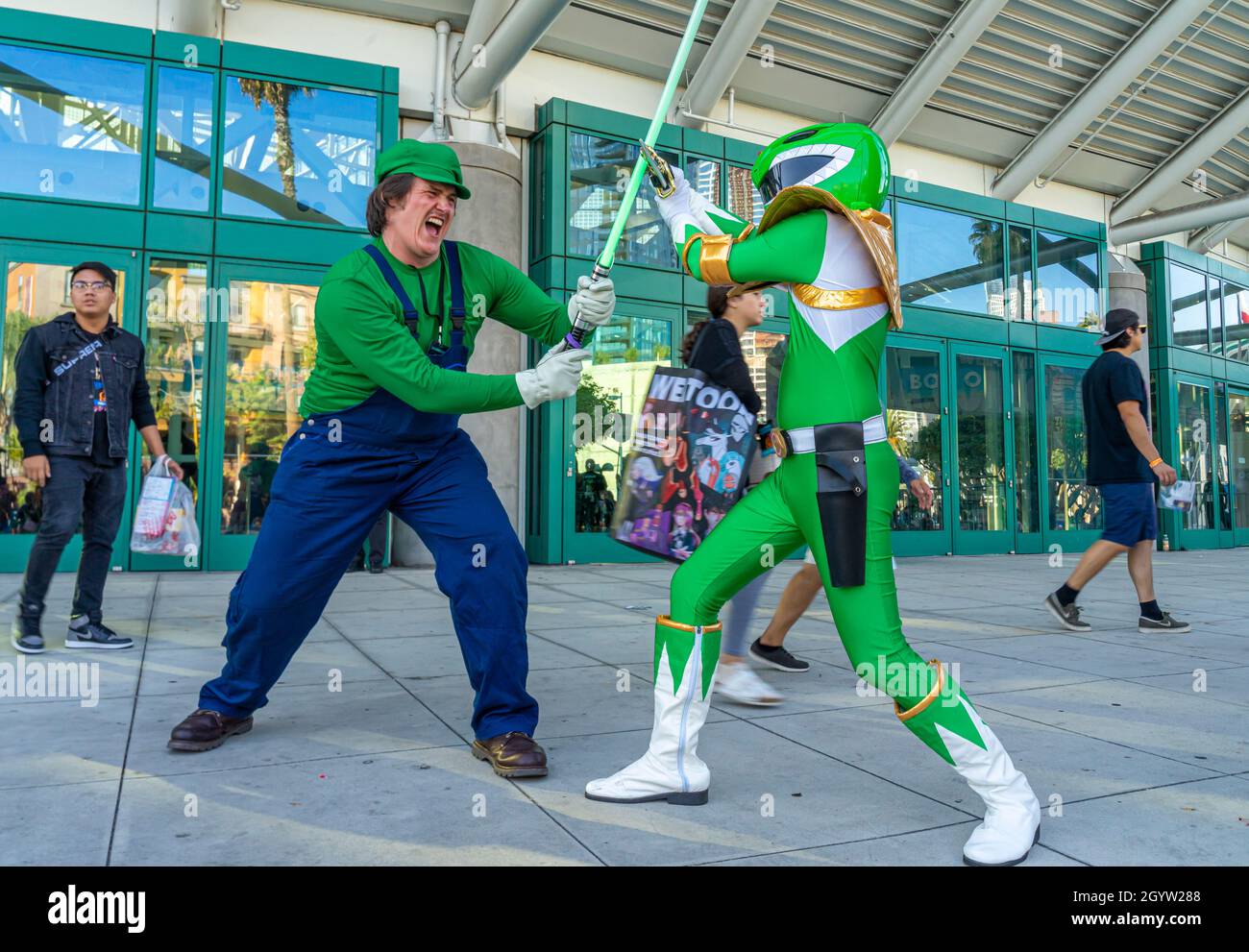 I partecipanti che ritraggono la spada Green Power Ranger combattono Super Mario coscrayer in uniforme al Comic con di Los Angeles, CA, Stati Uniti Foto Stock