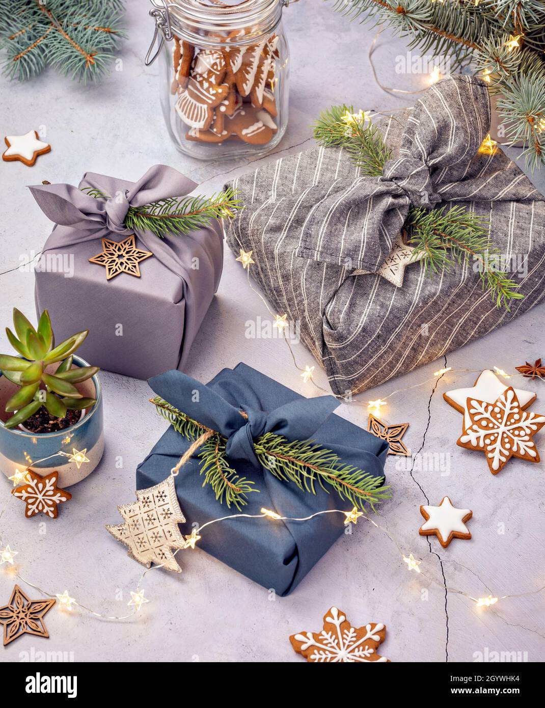 Zero rifiuti di Natale riciclaggio, riutilizzo, stile di vita sostenibile concetto. Confezione regalo ecologica in stile furoshiki e biscotti fatti in casa. Foto Stock