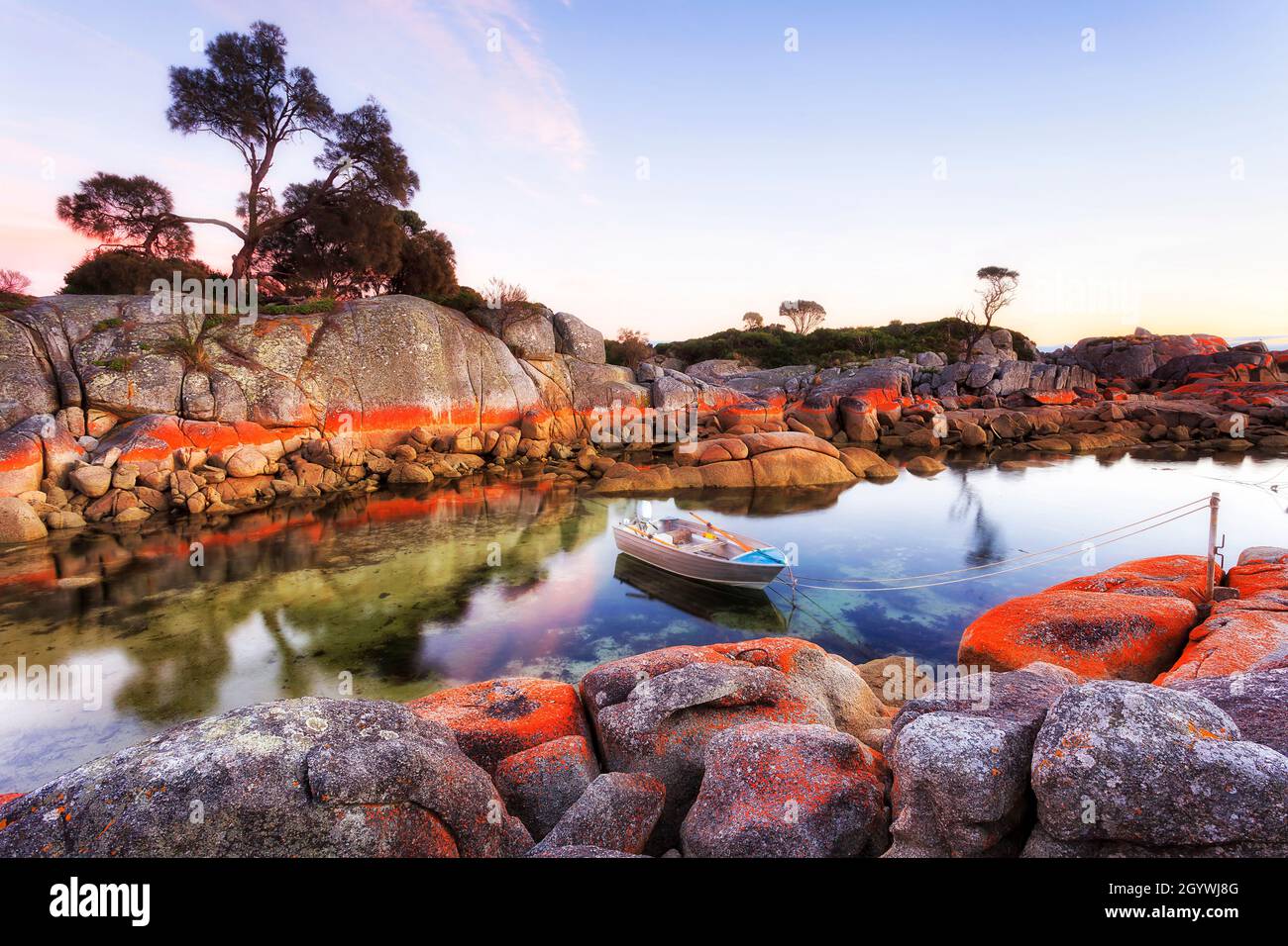 Piccola barca da pesca a motore con motore a benzina su una corda ormeggiata nella baia di Binalong del fuoco, Tasmania, Australia. Foto Stock