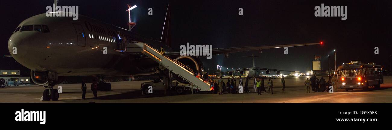 Gli evacuati salteranno a bordo di un volo per gli Stati Uniti dalla base aerea di Ramstein, Germania, 9 ottobre 2021. Gli evacuati sono stati processati attraverso un terminal passeggeri temporaneo che includeva controlli di sicurezza e bagagli prima di salire a bordo del volo. Questo è il primo volo a partire da Ramstein dopo una pausa di tre settimane. (STATI UNITI Illustrazione della Air Force di Airman Edgar Grimaldo) Foto Stock
