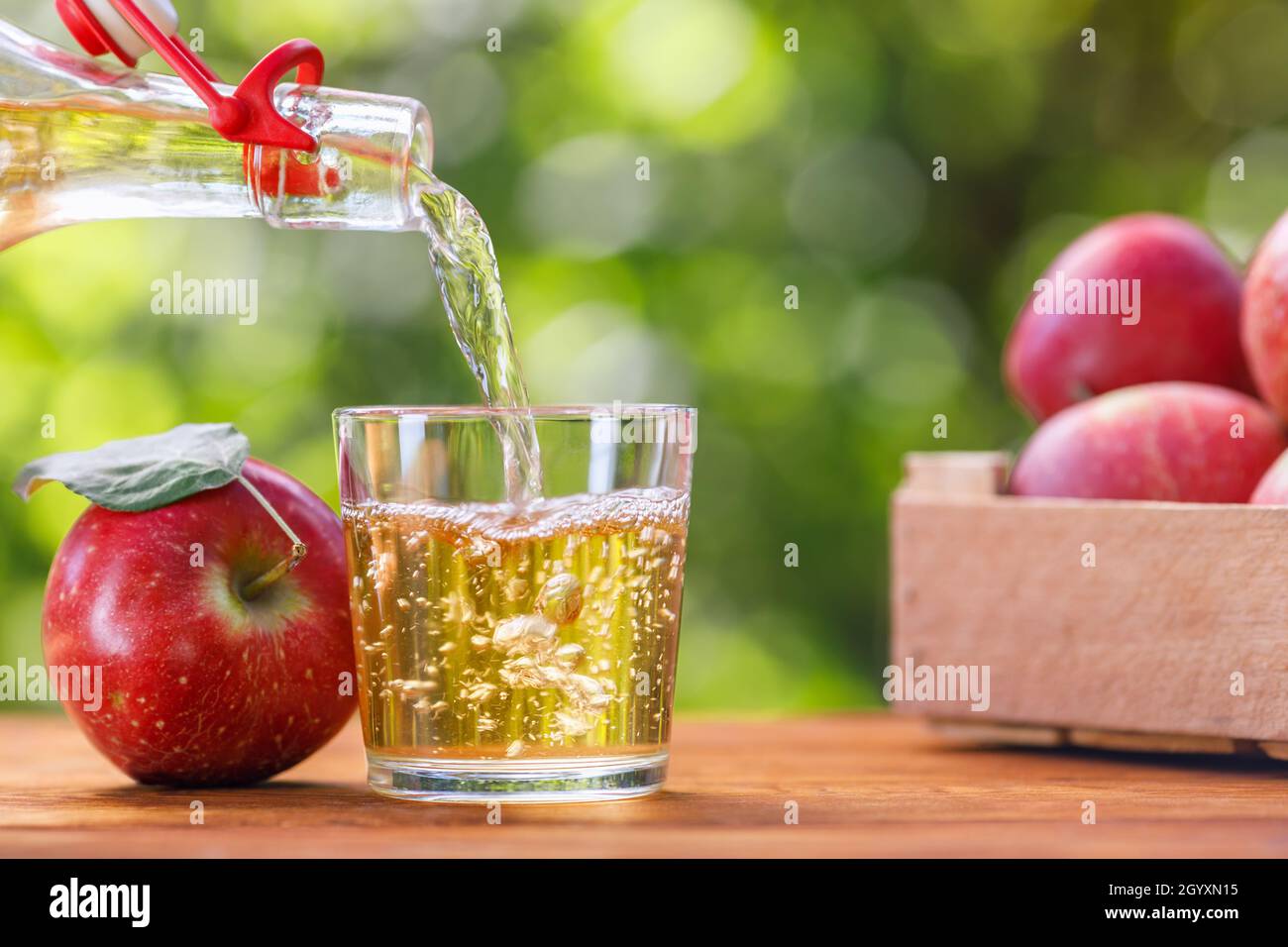 sidro di mele o succo versando in vetro dal flacone Foto Stock