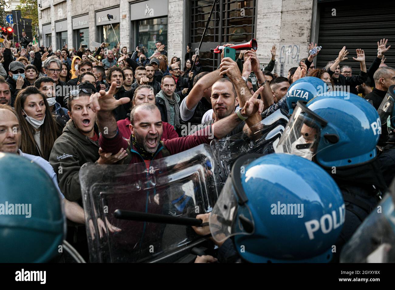 Milano, Italia. 9 ottobre 2021. Le persone si confrontano con gli ufficiali di polizia in marcia sommossa durante una demo No Green Pass per protestare contro l'introduzione delle misure del governo per combattere il covid-19 coronavirus pandemic Credit: Piero Crociatti/Alamy Live News Foto Stock