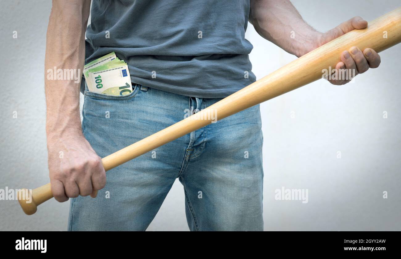Uomo con banconote in euro in tasca, tenendo una mazza da baseball nelle sue mani - minaccioso. Foto Stock