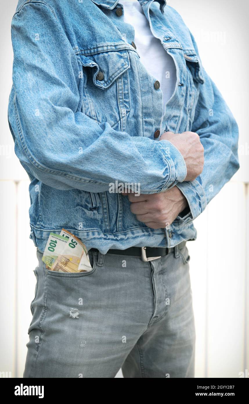 Giovane uomo in jeans con duecento euro bollette in tasca. Foto Stock