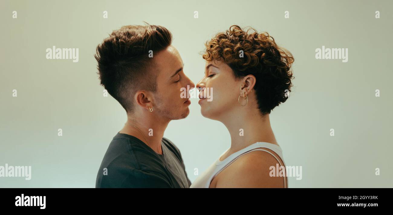 Una coppia di queer affettuosa che va per un bacio. Romantica giovane coppia queer in piedi l'uno vicino all'altro con gli occhi chiusi. Giovane LGBTQ+ colpo Foto Stock
