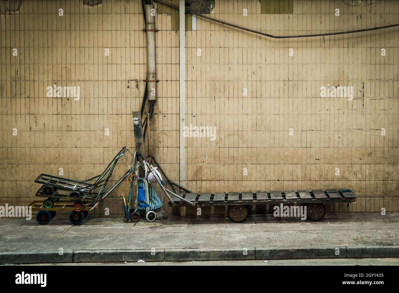 Scena stradale che mostra diversi tipi di carrelli per la movimentazione di merci e materiali a Hong Kong; Central, Hong Kong Island Foto Stock