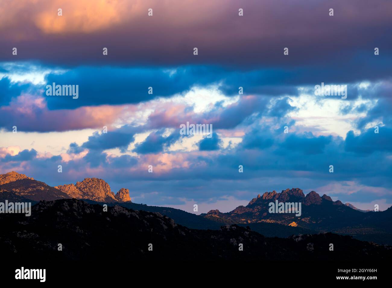 Vista mozzafiato della silhouette di una catena montuosa durante un'alba mozzafiato e nuvolosa. San Pantaleo, Sardegna, Italia. Foto Stock