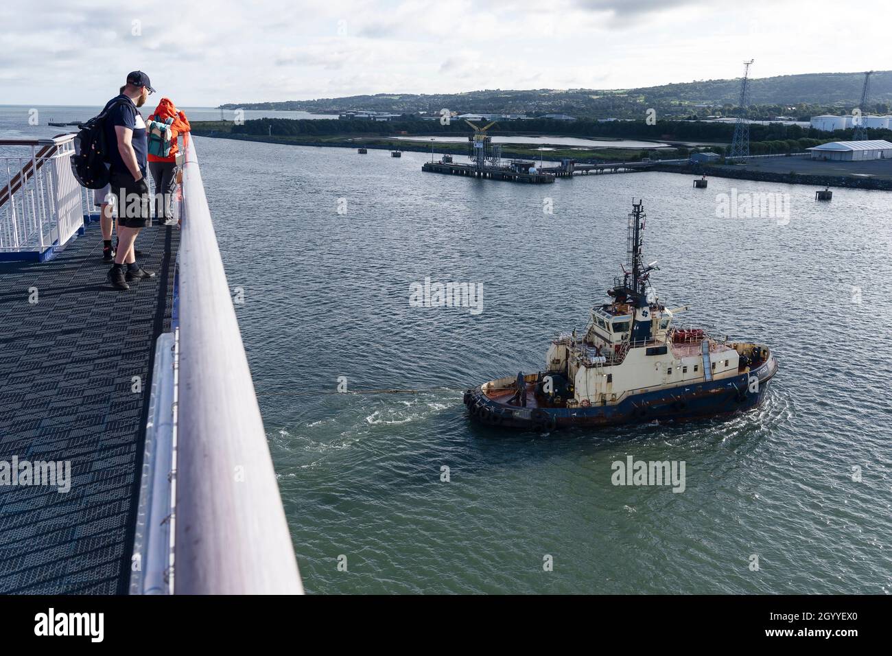 I passeggeri che guardano la nave da rimorchiatore Svitzer Sussex tirano il traghetto MS Stena Edda all'inizio di una traversata diurna da Belfast nell'Irlanda del Nord a Liverpool Foto Stock