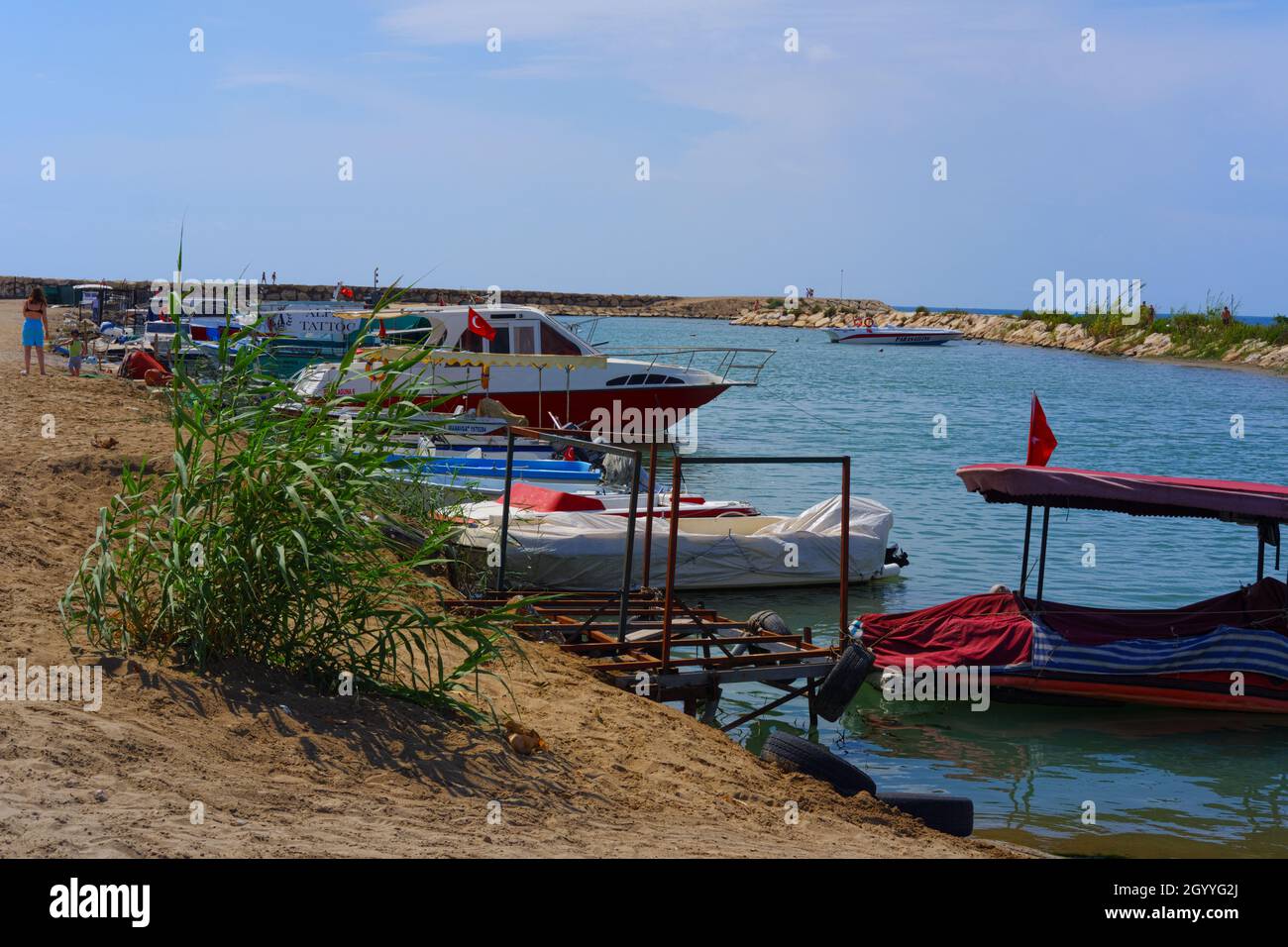 Piccole barche in legno al Porto piccolo con la costa sabbiosa in Antalya Turchia Foto Stock