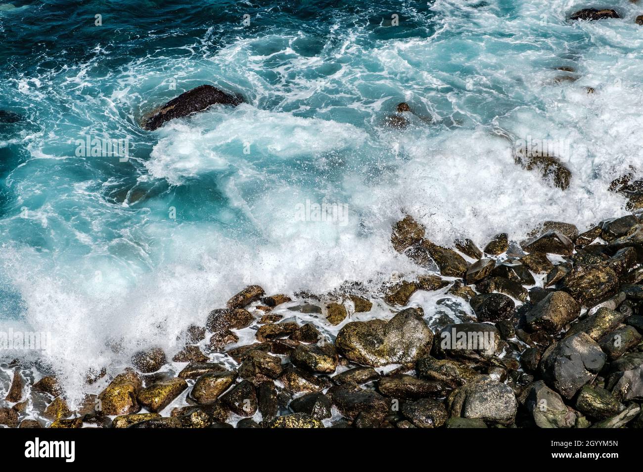le onde dell'oceano si infrangono sulle rocce sulla costa o sulla spiaggia Foto Stock