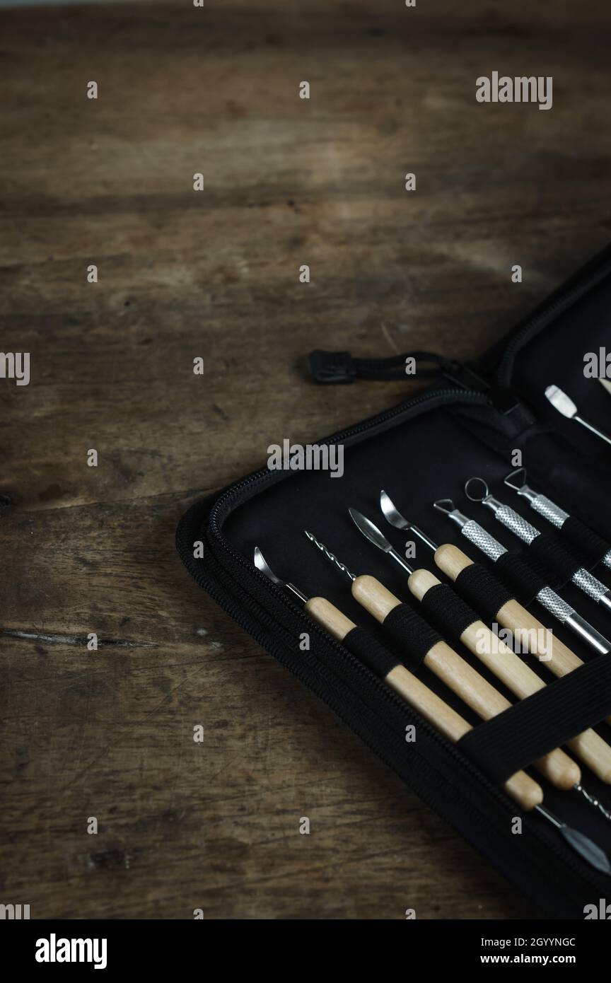 Kit di utensili per scultura su sfondo di un tavolo in legno. Primo piano dettaglio set di argilla ceramica o plastilina Foto Stock