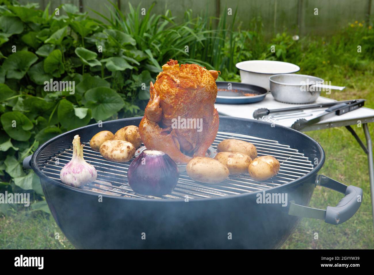 Carcassa di pollo e verdure cotte e affumicate su una griglia a carbone Foto Stock