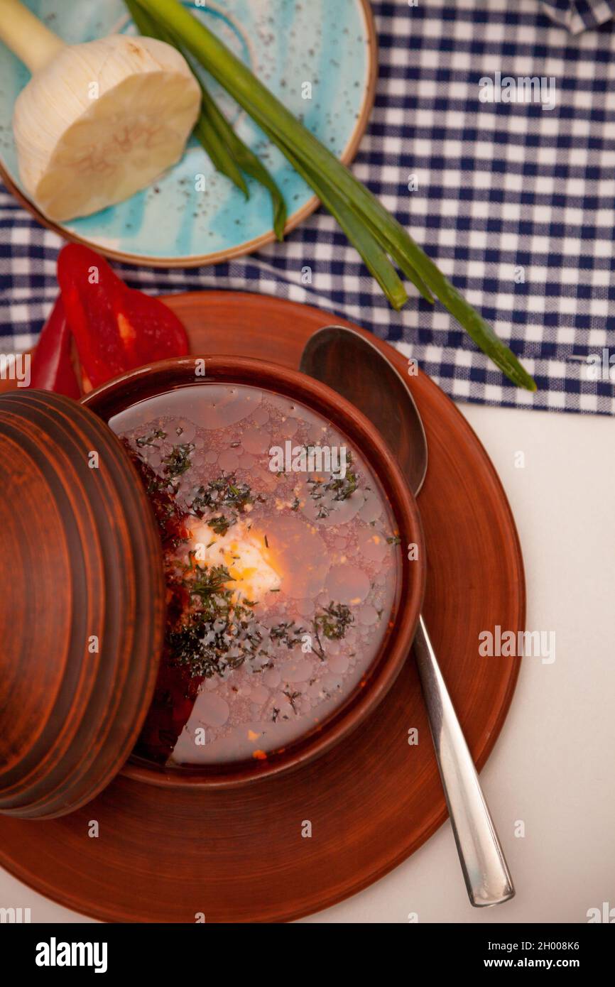 Borsch rosso ucraino con panna acida, aglio e cipolline verdi. Primo piatto. Cena. Un piatto tradizionale. Cibo ucraino sul tavolo. Foto Stock