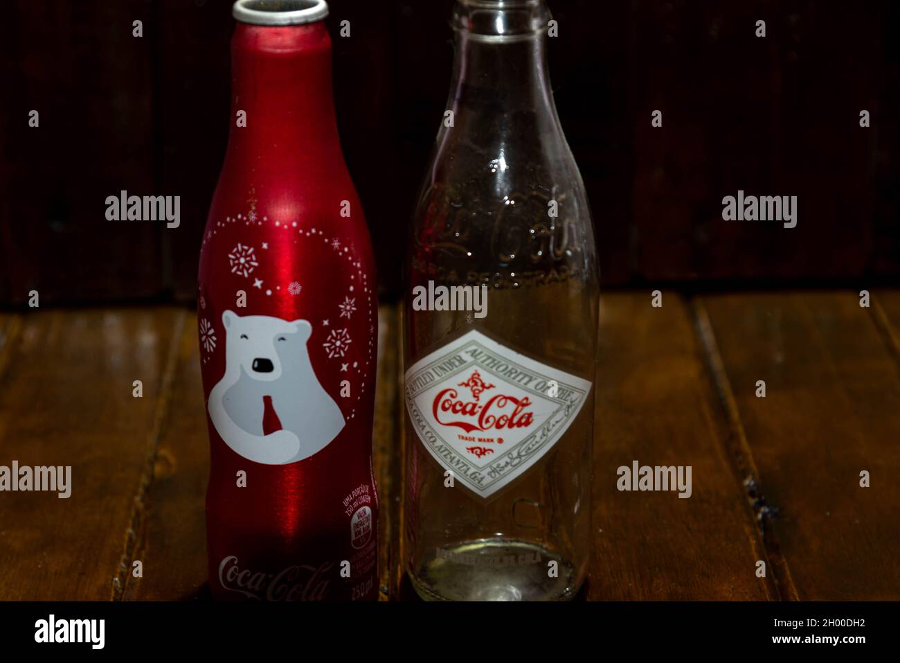 Bottiglie commemorative di coca cola su sfondo scuro. Articoli di raccolta. Vecchie bottiglie di soda. Icone da collezione. Foto Stock