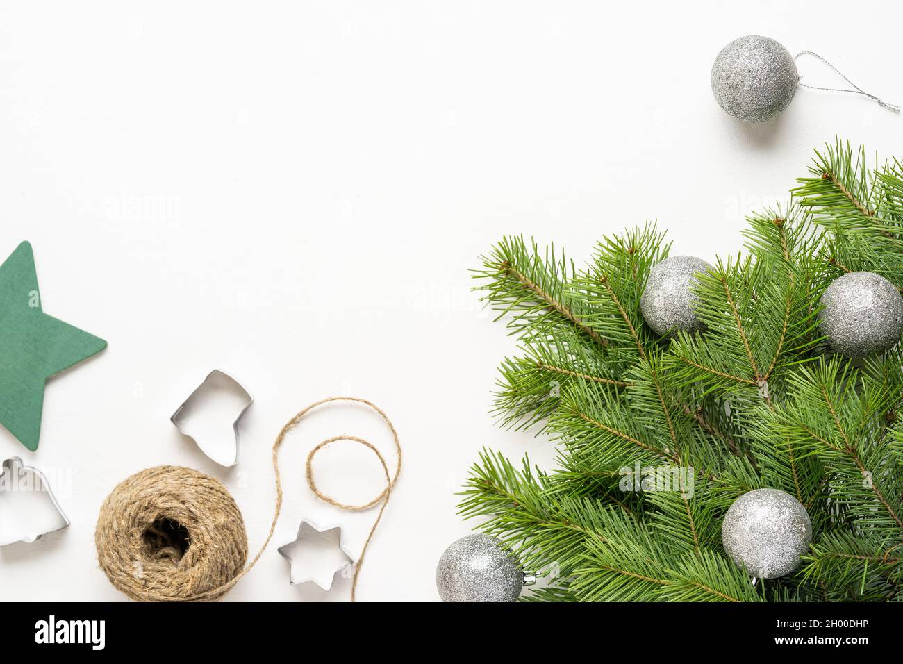 Rami verdi dell'albero di Natale, arance, ingredienti per biscotti allo zenzero su sfondo bianco, buon Natale e Capodanno. Vista dall'alto Foto Stock