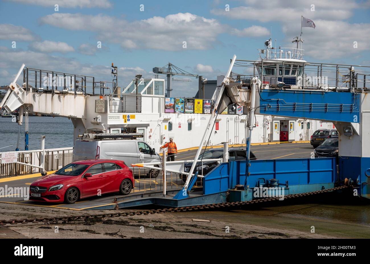 Torpoint, Cornovaglia, Inghilterra, Regno Unito. 2021. Auto rossa sulla rampa di scarico da un rotolo su rool fuori catena traghetto che attraversa il fiume Tamar tra Plymout Foto Stock