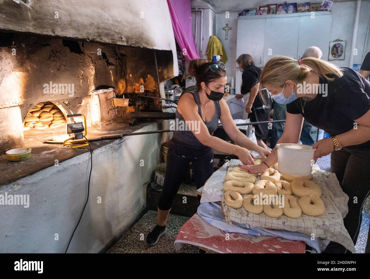 Donne che preparano il pane per la cottura in un forno tradizionale per il pane, Arsos Village Bakery, Cipro. Foto Stock