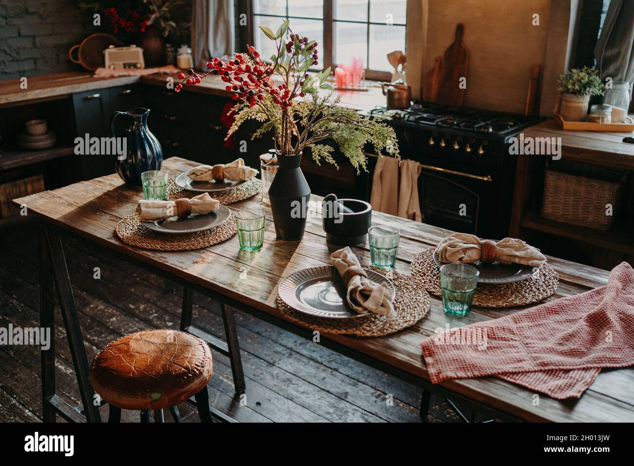 Tavolo servito per cena. Cucina interna accogliente. I tovaglioli e i tovaglioli sul tavolo per gli ospiti. Colazione per famiglie. Tempo di pranzo. Nessuna gente. Foto Stock