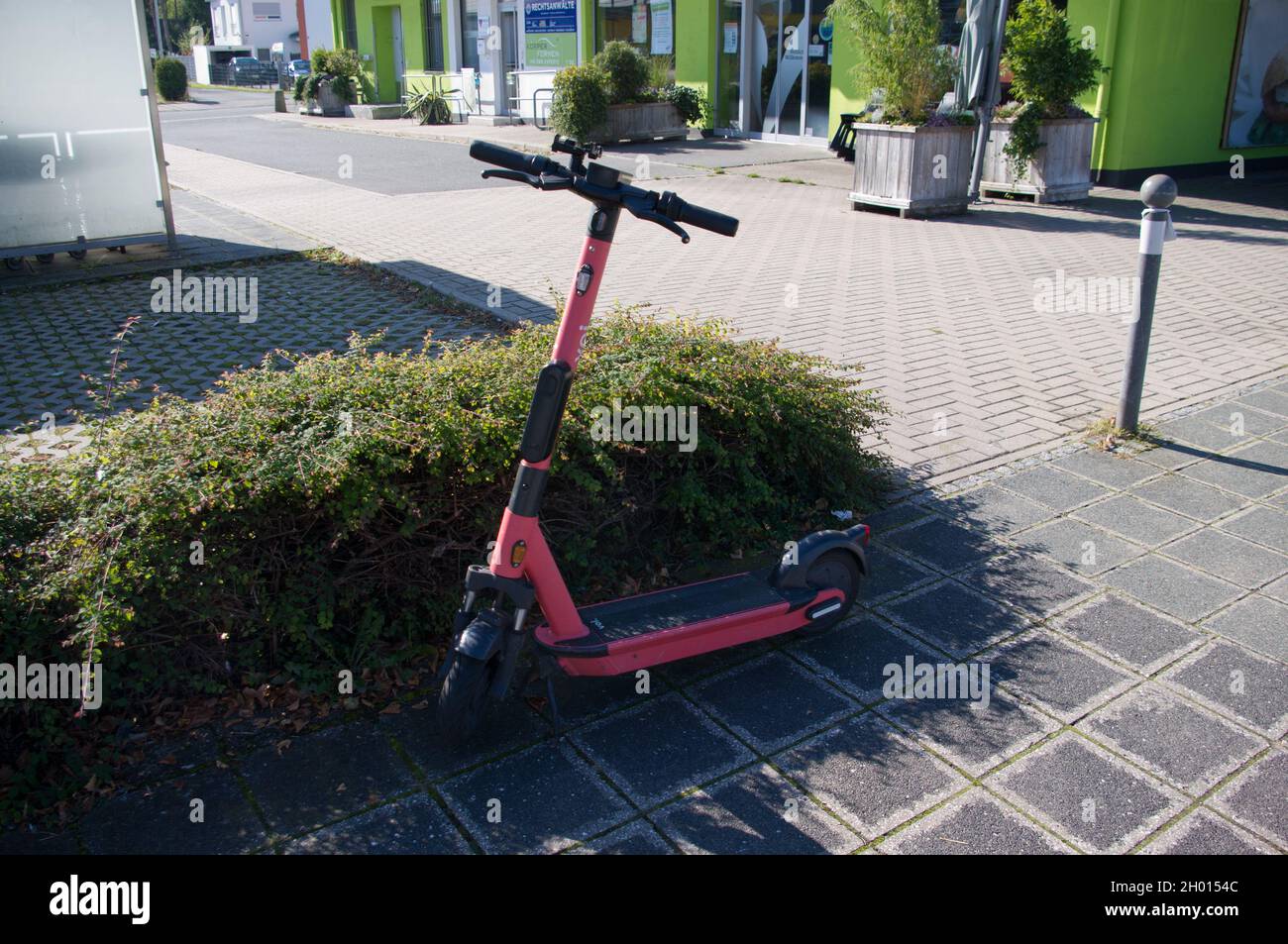 e-scooter singolo di fronte a una siepe Foto Stock