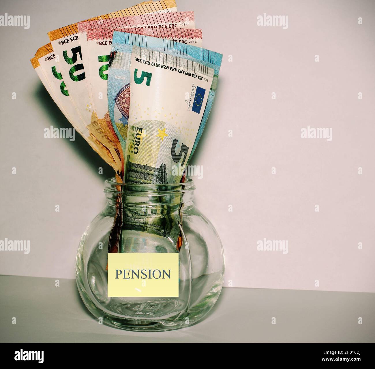 Banconote europee all'interno di un vaso con un adesivo giallo “pensione” concetto di pensionamento. Foto Stock