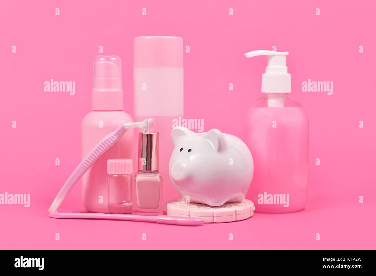 Il concetto di tassa rosa con la banca del piggy e il prodotto di igiene di colore rosa di stereotipo vario commercializzato alle donne Foto Stock