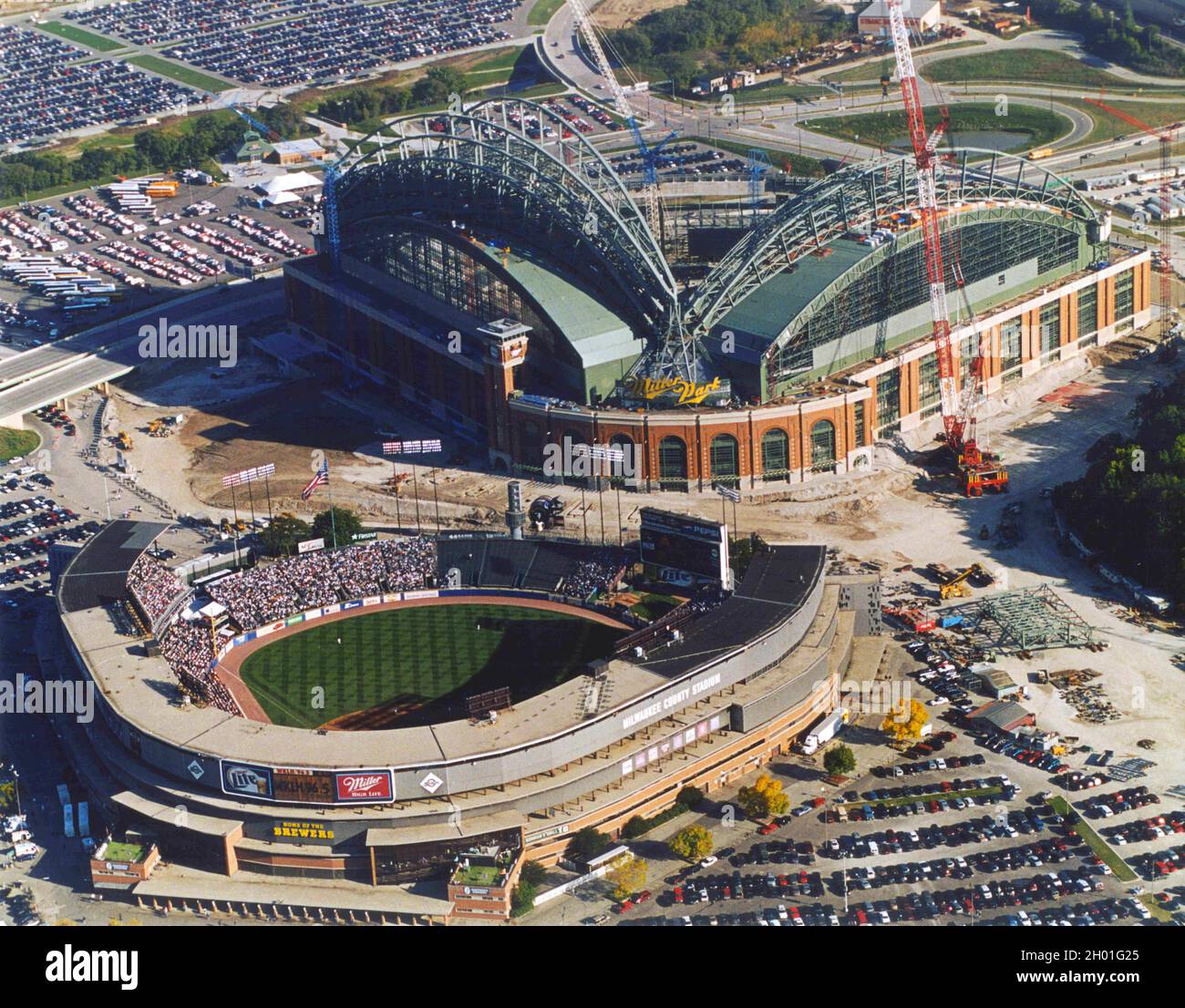 Milwaukee, Wisconsin, Stati Uniti. 28 settembre 2000. Due stadi simboleggiano il matchup nella National League Division Series. Il Milwaukee County Stadium, in basso, fu la sede dei Milwaukee Braves dopo il loro trasferimento da Boston nel 1954, fino al loro trasferimento ad Atlanta nel 1966. Fu allora sede dei Milwaukee Brewers dal 1970 al 2000 settembre. Lo stadio fu demolito nel 2001 quando Miller Park, sopra, aprì come nuova sede dei Brewers. Questa foto è stata scattata durante l'ultima partita in County Stadium 29 settembre 2000. I Brewers furono sconfitti dai Cincinnati Reds, 8-1 Miller Park o Foto Stock