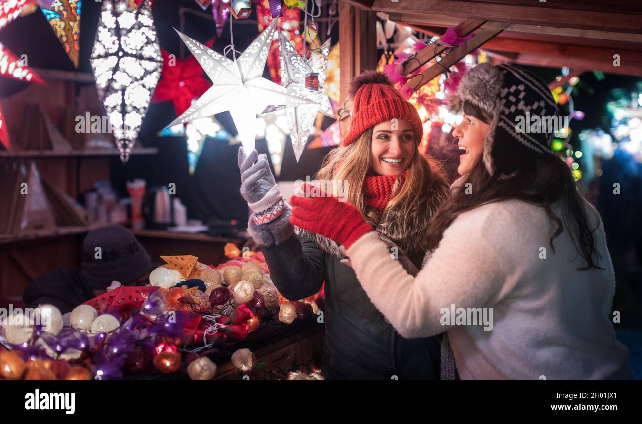 Due amici che acquistano decorazione di Natale sul mercato invernale Foto Stock