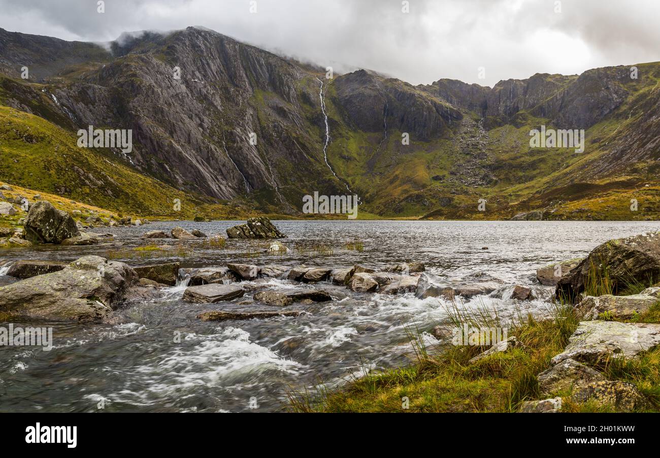 L'acqua piovana cade lungo il monte Glyderau causando il flusso dell'acqua nel lago Idwal verso Ogwen nel Parco Nazionale di Snowdonia nell'ottobre 2021. Foto Stock