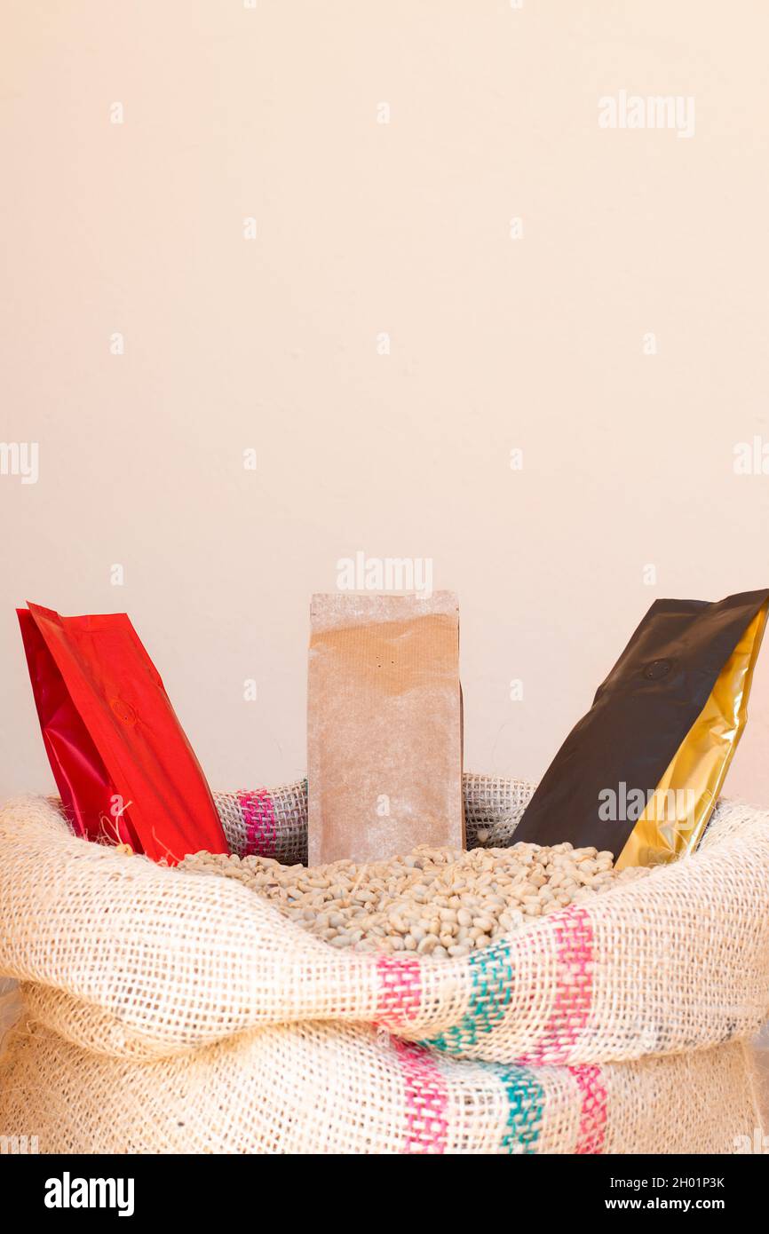 Sacchetti di carta per l'imballaggio di caffè o fagioli. Borse colorate di lusso, rosse, beige e nere con oro. Imposta il tono di Champagne Sail. Sacco con caffè. Verticale Foto Stock