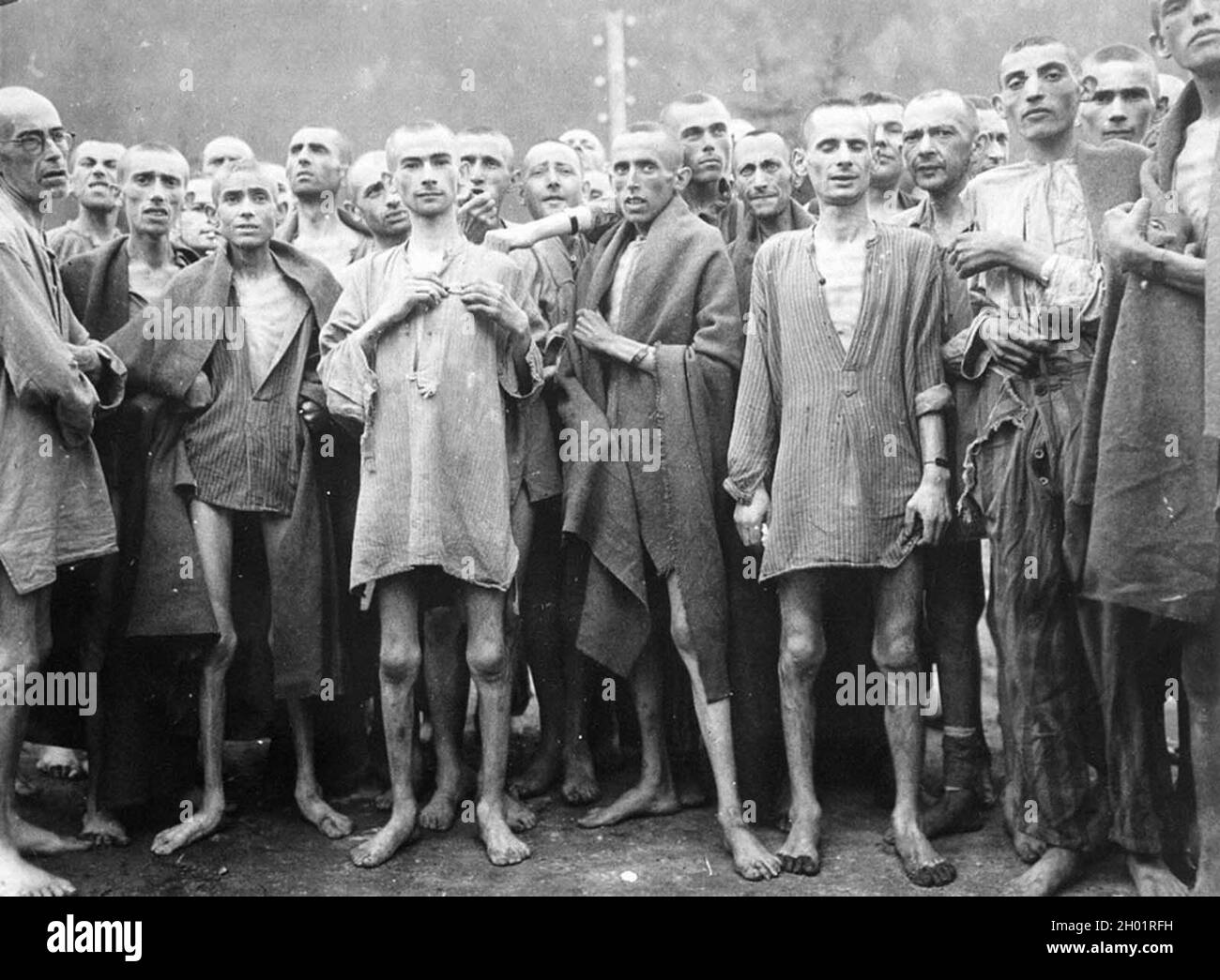 I prigionieri affamati, quasi morti di fame, si pongono in un campo di concentramento di Ebensee, in Austria, il 7 maggio 1945. Foto Stock