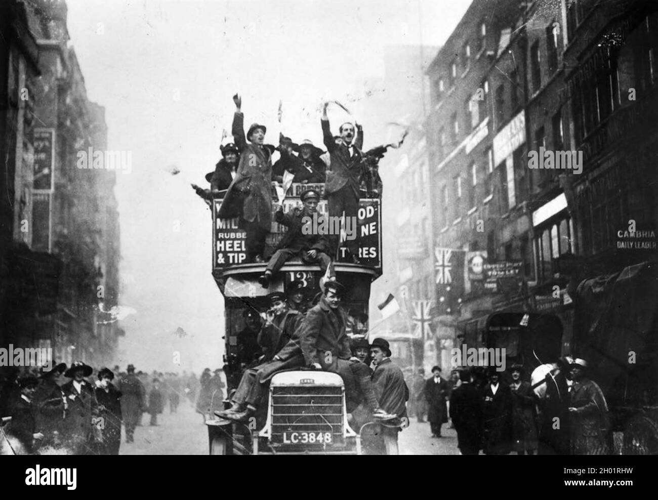 Le folle di Londra celebrano la firma dell'Armistice, con persone dentro e su un autobus di Londra Foto Stock