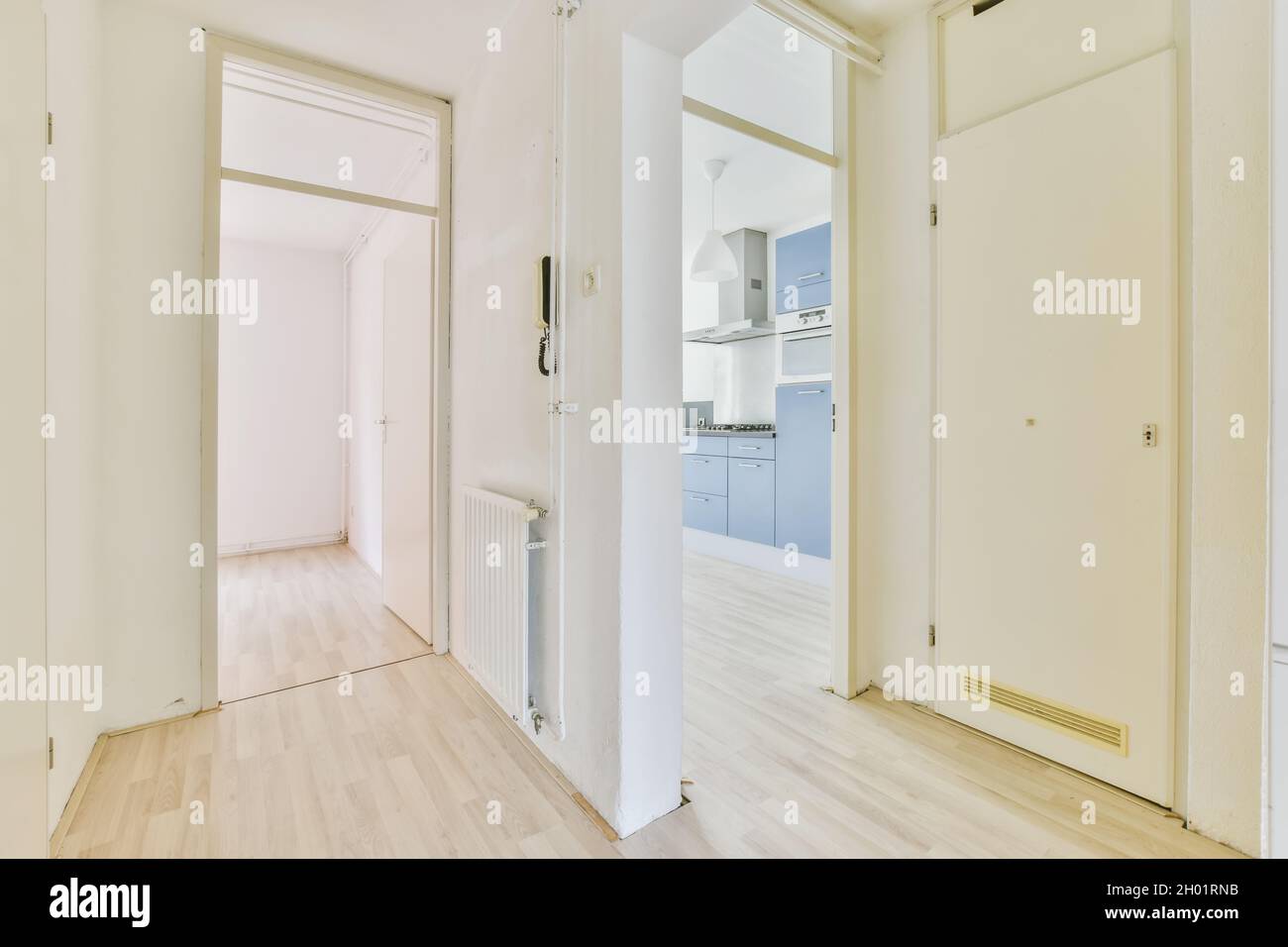 Un'immagine interna di stanze vuote con pareti bianche e un pavimento in legno Foto Stock
