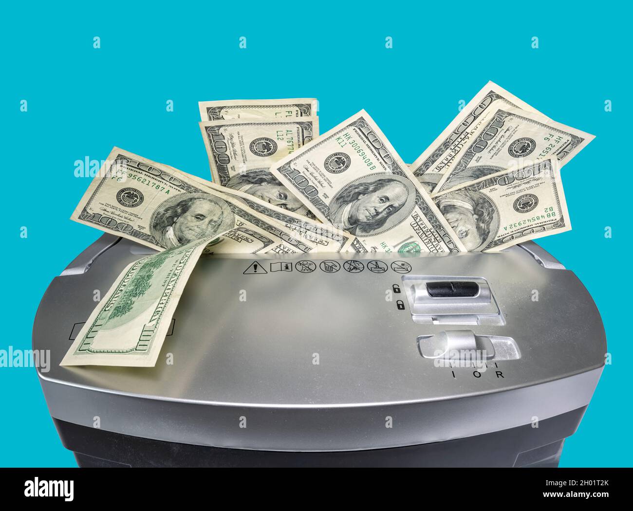 Foto di concetto di una bolletta da 100 dollari che viene sminuzzata da un tritadocumenti raffigurante il valore indebolito del dollaro. Isolato su sfondo blu fisso. Clippin Foto Stock