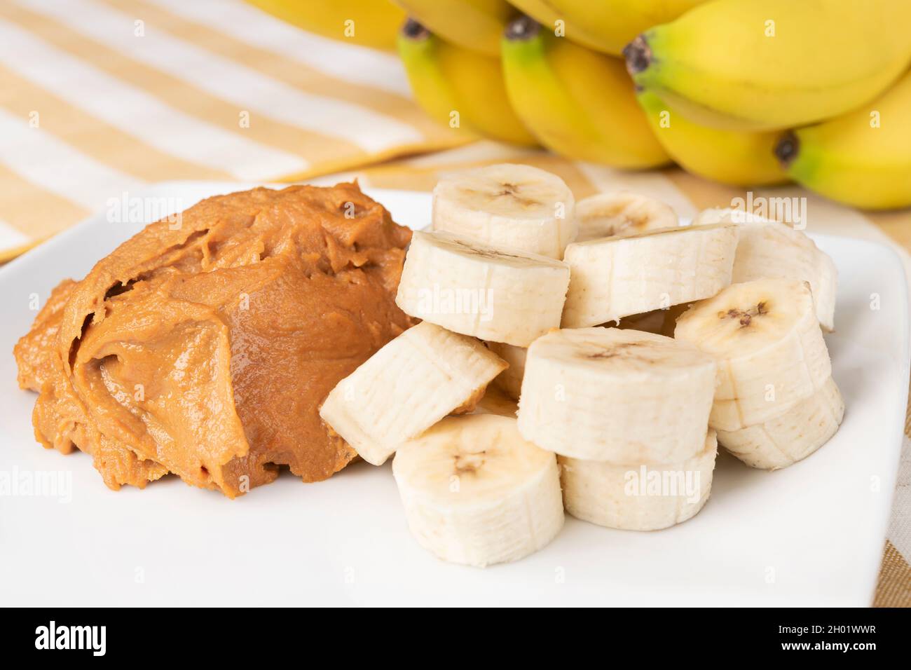 Una pila di fette di banana sane con burro di arachidi aggiunge carboidrati sani alle proteine per una buona perdita di peso. Foto Stock