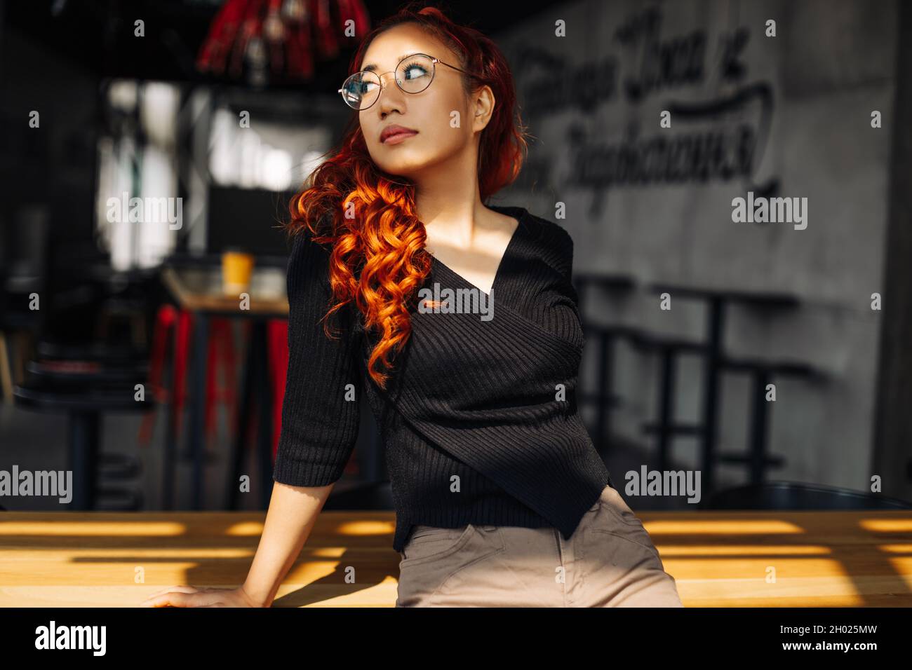 Ritratto di una donna asiatica sorridente che indossa occhiali, bella donna coreana che posa guardando la macchina fotografica in posa per la foto Foto Stock