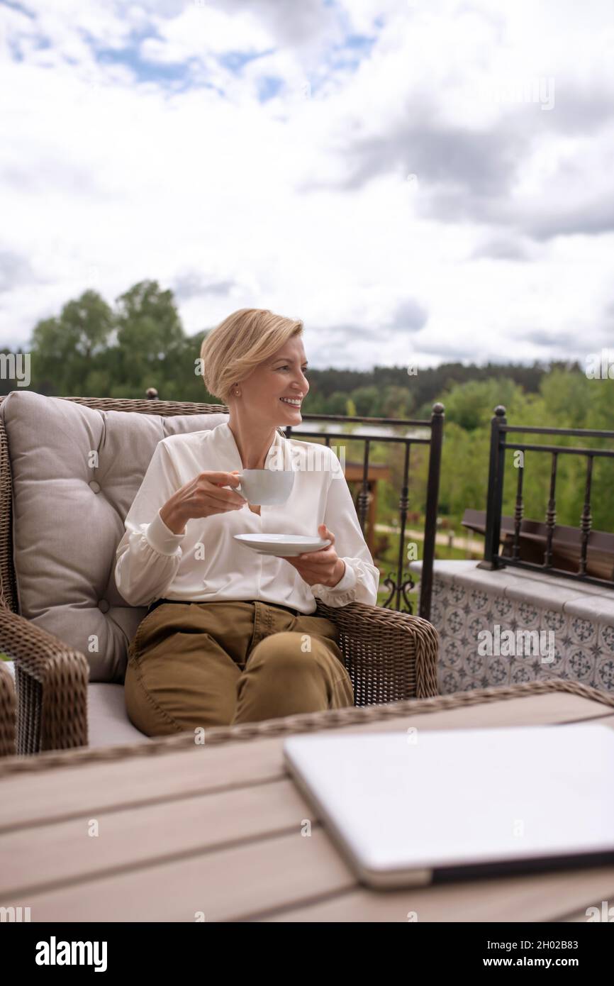 Signora bionda attraente godendo la sua colazione all'aperto Foto Stock