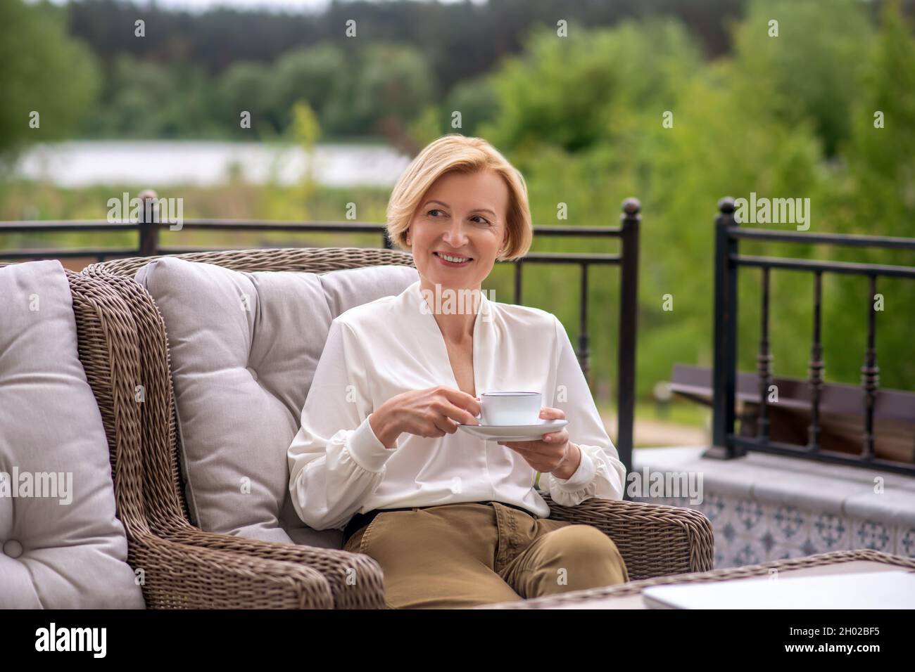 Contented piacevole aristocratica donna godendo la sua pausa caffè all'aperto Foto Stock