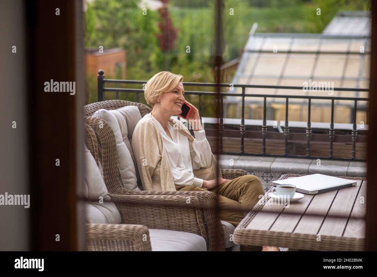 Felice signora di mezza età che parla sullo smartphone all'aperto Foto Stock