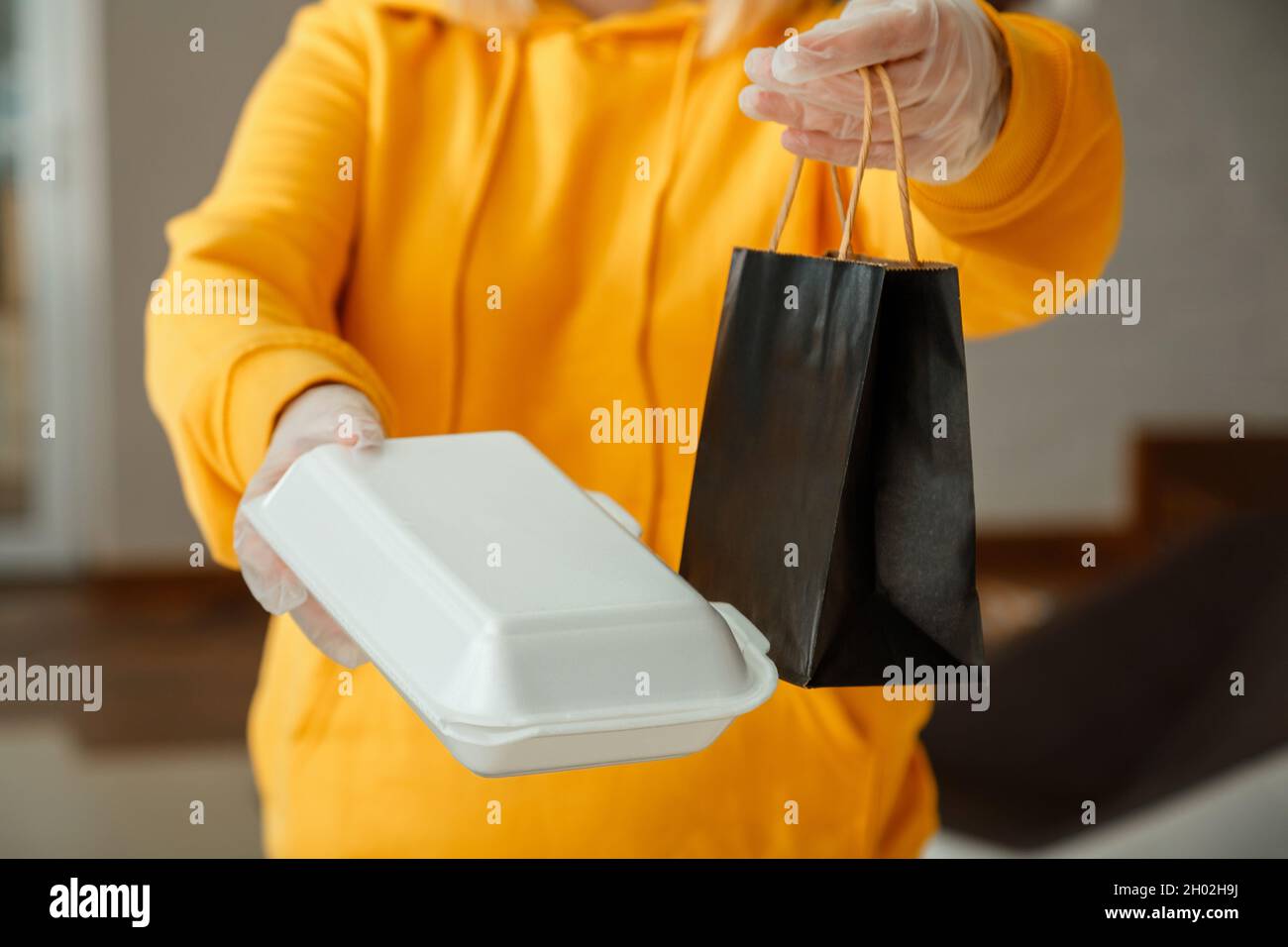 Sacchetto di carta da asporto, contenitore in polistirolo. Pacchetto pranzo con sacco da asporto per andare al ristorante da asporto. Il lavoratore della cucina emette ordini online in Foto Stock
