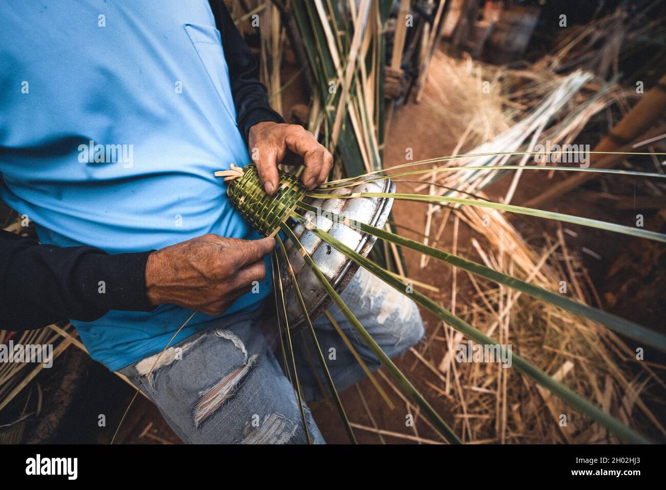 Le mani che tessono i cestini di bambù nel paese, fanno un cestino Foto Stock