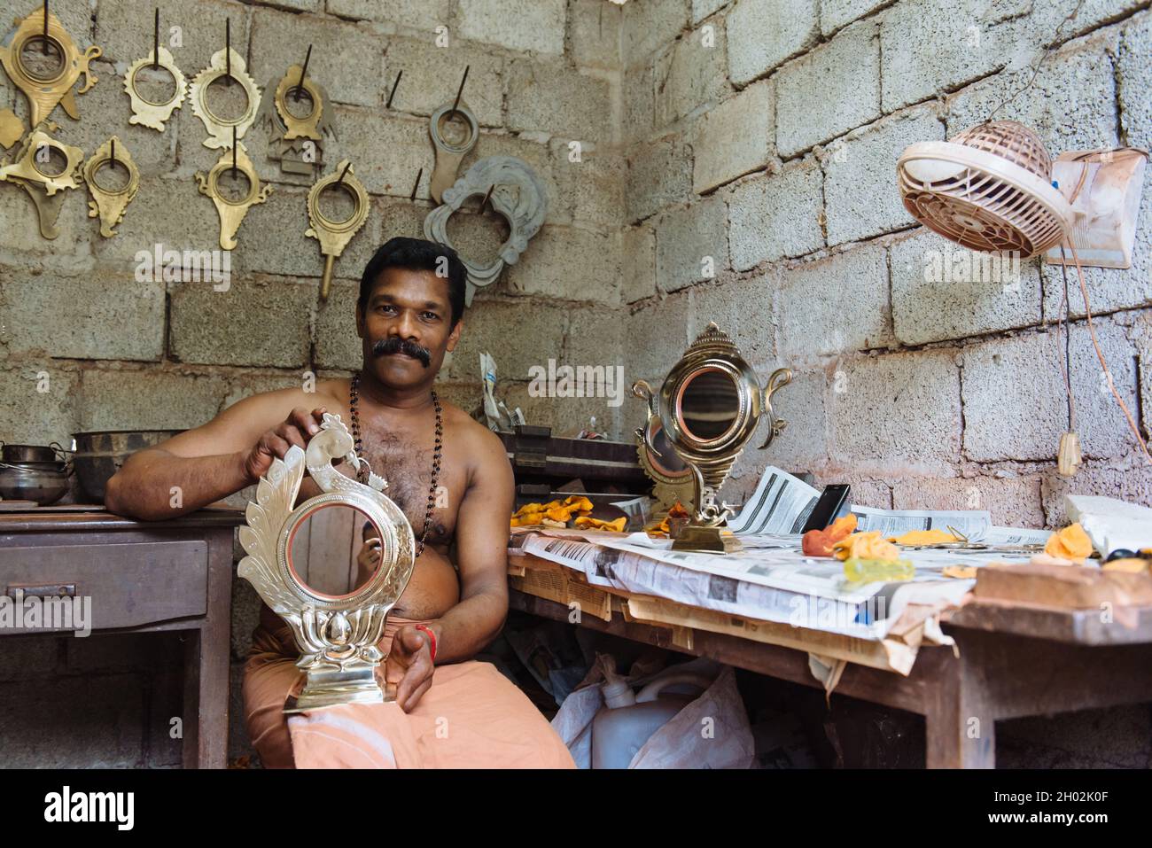 Aranmula, India - 5 dicembre 2015: Kerala, specchi d'argento produzione artigianale in zona rurale, l'uomo fa artigianato unico lavoro d'arte. Piccola famiglia Foto Stock